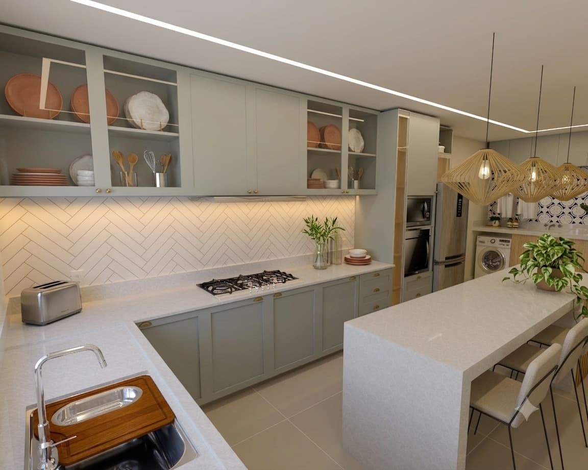 Cozinha integrada com marcenaria verde-acinzentada, cooktop e bancada em ilha com mesa de jantar